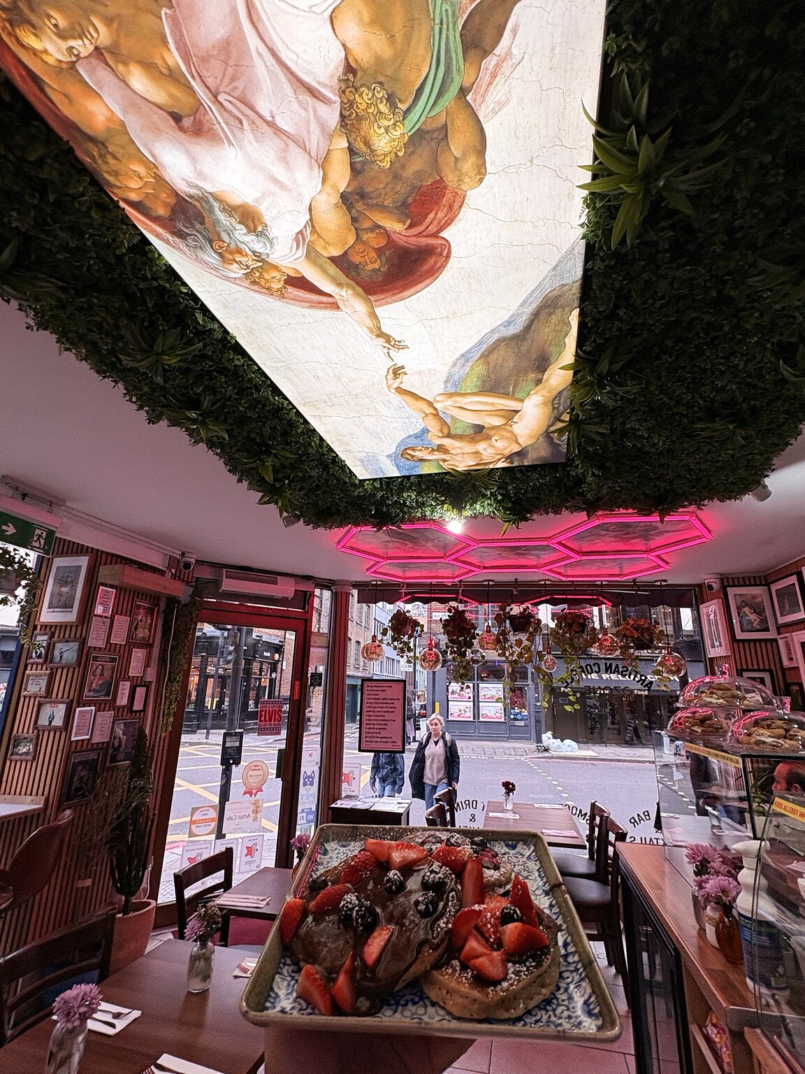 Interior do Artist Cafe London com mesas, luz quente e detalhes artísticos